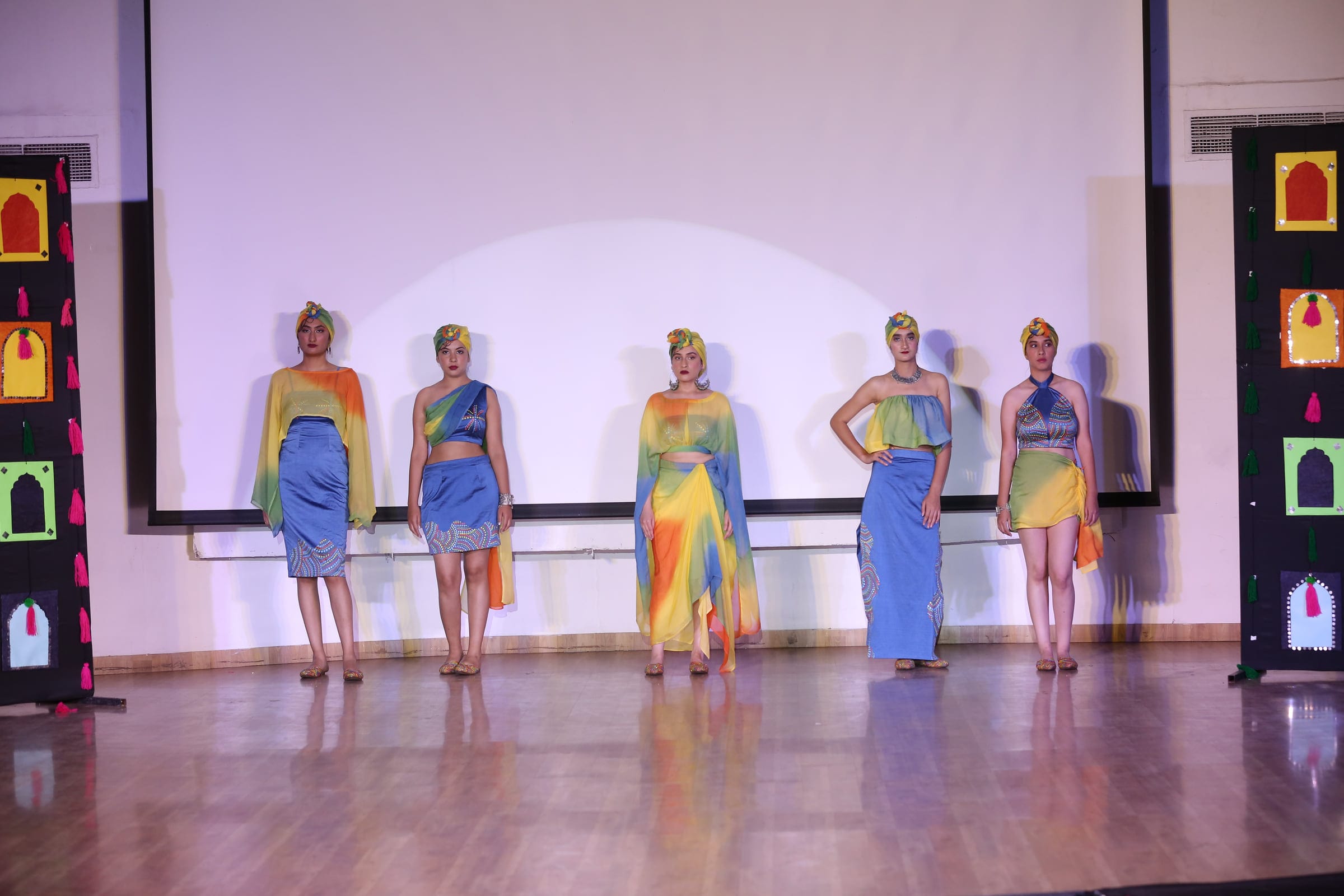 All five looks of Tribal Threads standing together on stage