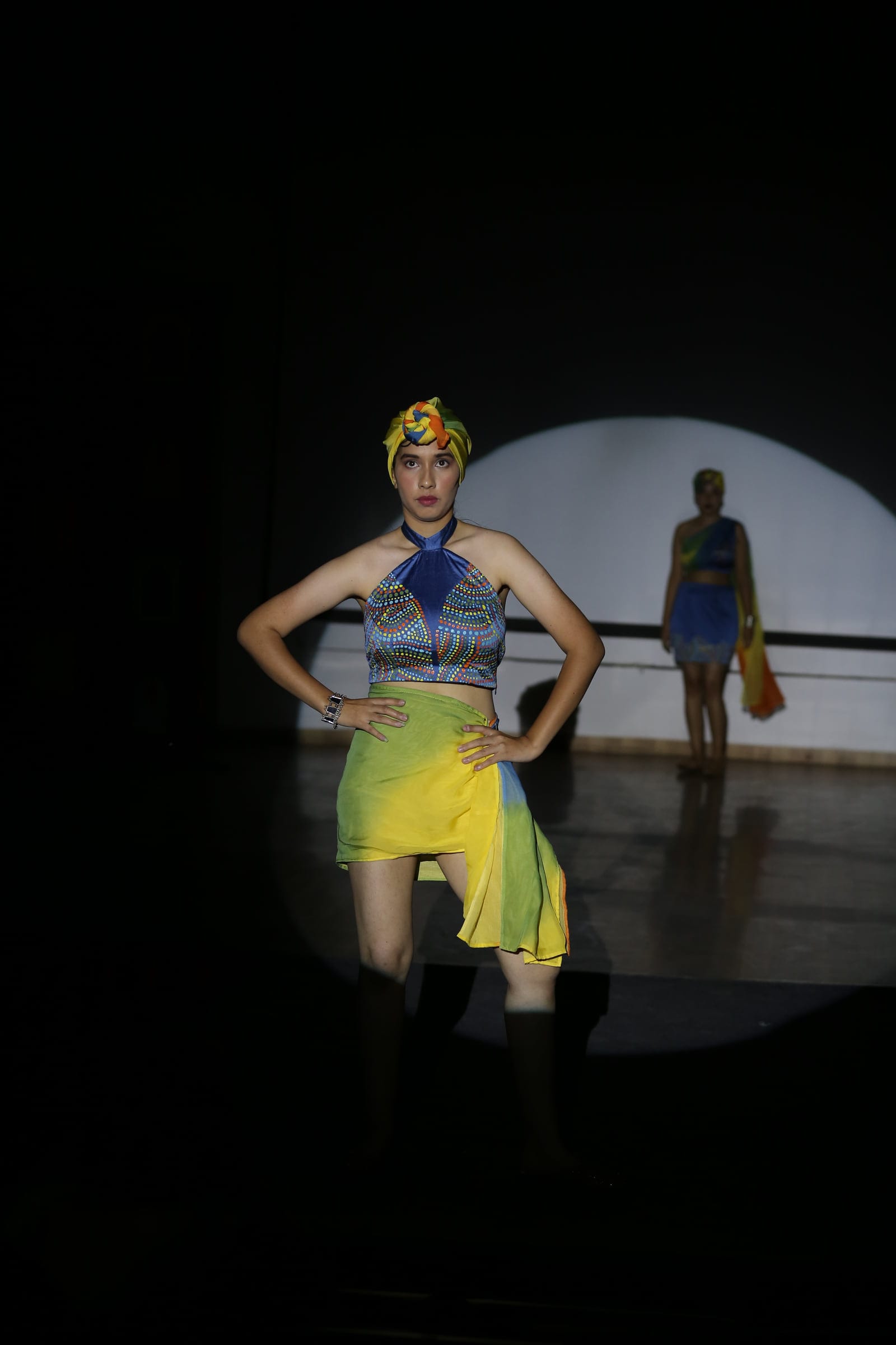Halter top and asymmetric skirt under a spotlight